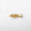 A small golden musical instrument, possibly a trumpet or clarinet, is shown against a white background.