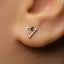 A close-up of a person's ear with a small silver triangle-shaped earring.