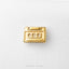 A small golden object resembling a cassette tape is shown against a white background.