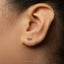 A close-up view of a person's ear with a small silver earring in the earlobe.