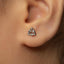 A close-up of a person's ear with a small silver earring in the earlobe.