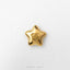 A shiny gold star-shaped charm with a smiley face on it, placed on a white background.