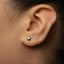 A close-up of a person's ear with a small star-shaped earring in the earlobe.