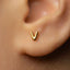 A close-up of a person's ear with a small gold earring in the earlobe.