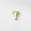 A single, shiny gold letter 'T' on a plain white background.