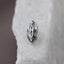 A silver-colored metal object resembling a stylized female figure is displayed against a white background.