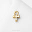 A small gold-colored pendant in the shape of the Egyptian hieroglyphic symbol, which is the Ankh, is shown against a white background.