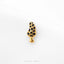 A gold-colored mushroom-shaped pin with black spots is shown against a white background.