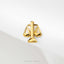 A gold-colored pendant in the shape of a scale, symbolizing justice or fairness.