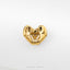 A gold-colored metal object resembling a heart shape is displayed against a white background.