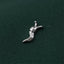A silver metal object resembling a snail or slug is resting on a dark green fabric.