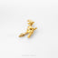 A small gold-colored charm in the shape of a witch on a broomstick.