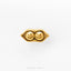 A gold-colored earring with two smiling faces on either side of a heart shape.