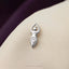 A silver pendant in the shape of a female figure is resting on a beige fabric surface.