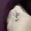 A silver key-shaped pendant with a skull design is attached to a beige fabric.