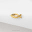 A gold-colored fish-shaped earring is shown against a white background.