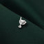 A small silver pin or badge is resting on a dark green fabric.