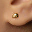 A close-up view of a person's ear with a small gold earring in the earlobe.