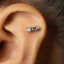 A small silver earring with a gemstone is visible in the image.