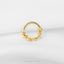 A gold-colored ring with a star-shaped design on a white background.