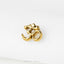 A gold-colored metal symbol resembling the Om or Aum symbol, which is a significant symbol in Hinduism and yoga.