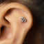 A silver earring with the Om symbol is visible in the image.