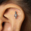 A small silver earring in the shape of a human figure is visible in the person's ear.