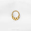 A gold-colored metal ring with a textured surface, placed against a white background.