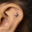A star-shaped earring with a gemstone is visible in the image.