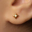 A close-up view of a person's ear adorned with a small gold star-shaped earring.