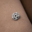 A silver pentagram charm is resting on a textured fabric surface.