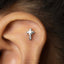 A small silver cross-shaped earring is visible in the image.