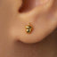 A close-up of a person's ear with a small gold earring in the earlobe.