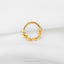 A gold-colored ring with a star-shaped design on a white background.