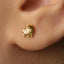 A close-up of a person's ear with a small gold earring in the earlobe.