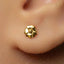 A close-up view of a person's ear with a small gold earring in the earlobe.