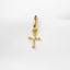 A gold-colored cross-shaped charm or earring is shown against a white background.