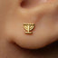 A close-up of a person's ear wearing a small gold earring with a menorah symbol on it.