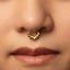 A close-up portrait of a young woman with a gold nose ring, her eyes gazing directly at the camera.