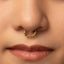 A close-up portrait of a young woman with a nose ring, looking directly at the camera with a neutral expression.