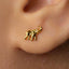 A close-up of a person's ear with a small gold elephant earring in the earlobe.