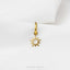 A gold-colored charm in the shape of a sun is hanging from a gold-colored hook against a white background.