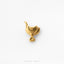 A small gold-colored metal object resembling a horseshoe or horseshoe-shaped charm is shown against a white background.