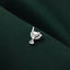 A small silver pin or badge is resting on a dark green fabric.