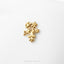 A small gold-colored flower brooch or pin is displayed against a white background.