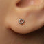 A close-up view of a person's ear with a small silver earring in the earlobe.