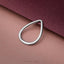 A silver teardrop-shaped ring is resting on a textured pink background.