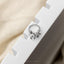 A silver ring with an octopus design is placed on a white surface.