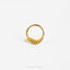 A gold-colored ring with a decorative design, placed against a white background.