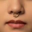 A close-up portrait of a young woman with a nose ring, looking directly at the camera with a serious expression.